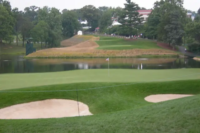 The photograph: the 10th green at Congressional across a pond, two bunkers in front and trees and the clubhouse behind.